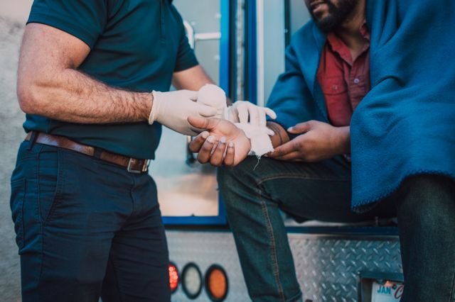 A medic bandaging an injured hand.