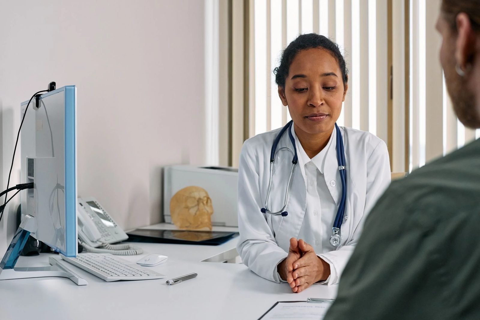 A doctor and patient talking through symptoms during an appointment.