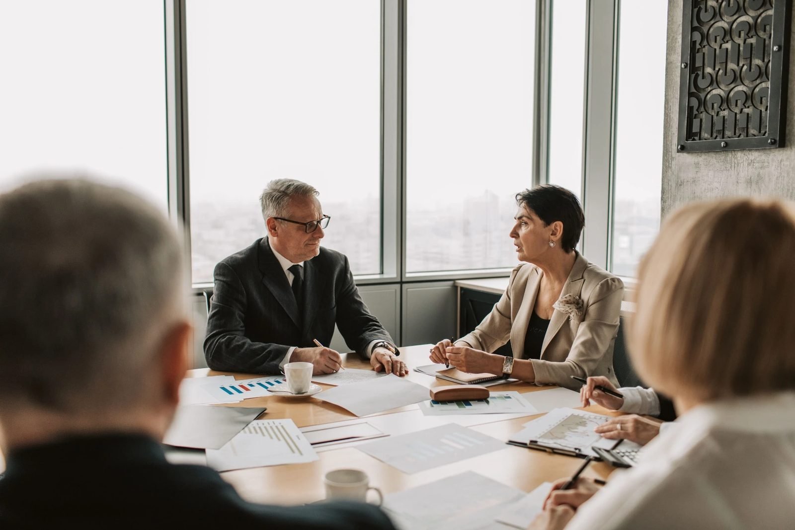 People reviewing documents around a conference table while weighing a decision.